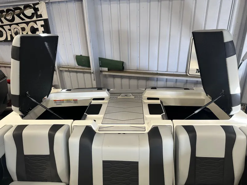 Slide: The Image of 2025 Malibu 23 MXZ boat interior with open storage compartments, showcasing sleek design and functionality. - 7