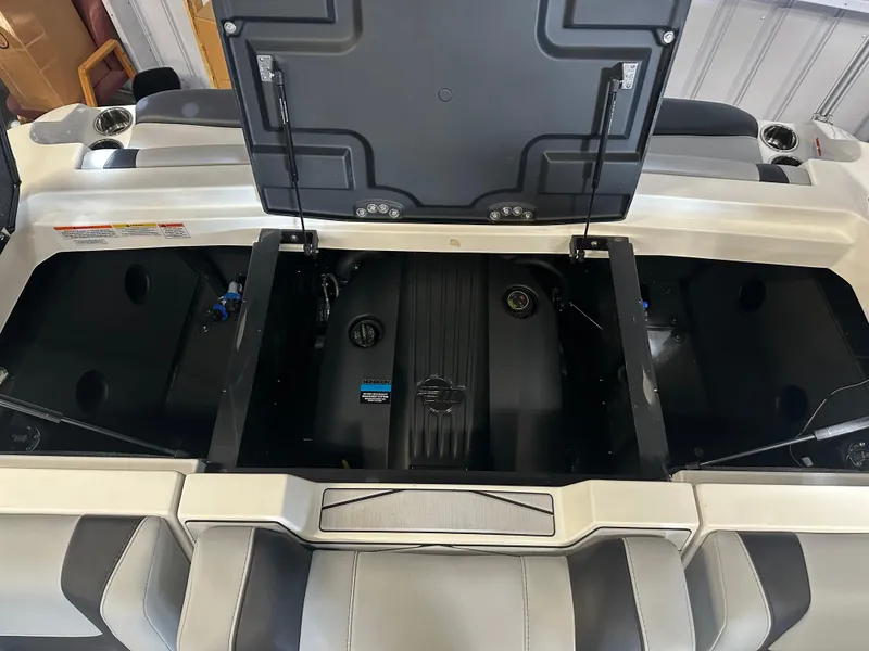 Slide: The Image of 2025 Malibu 23 MXZ boat engine compartment with open hatch, showcasing engine details. - 8