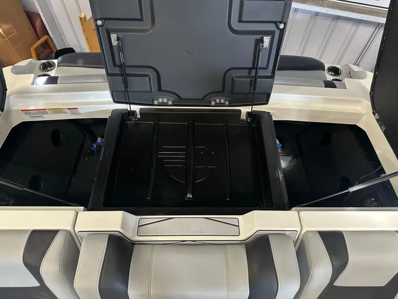 Slide: The Image of 2025 Malibu 23 MXZ boat storage compartment, open lid, sleek design, spacious interior. - 9