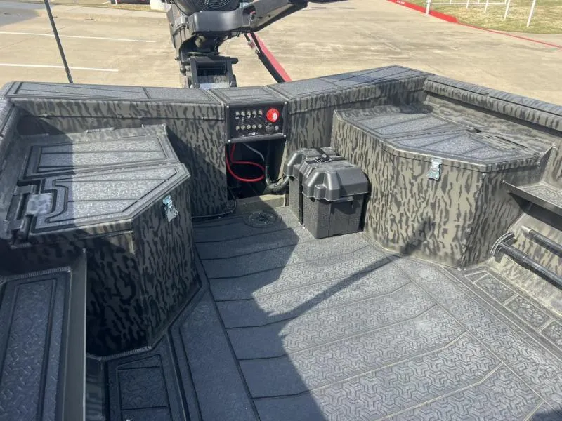 Slide: The Image of 2025 Gator Tail 17/50 Savage Series boat interior with camo design and control panel. - 12