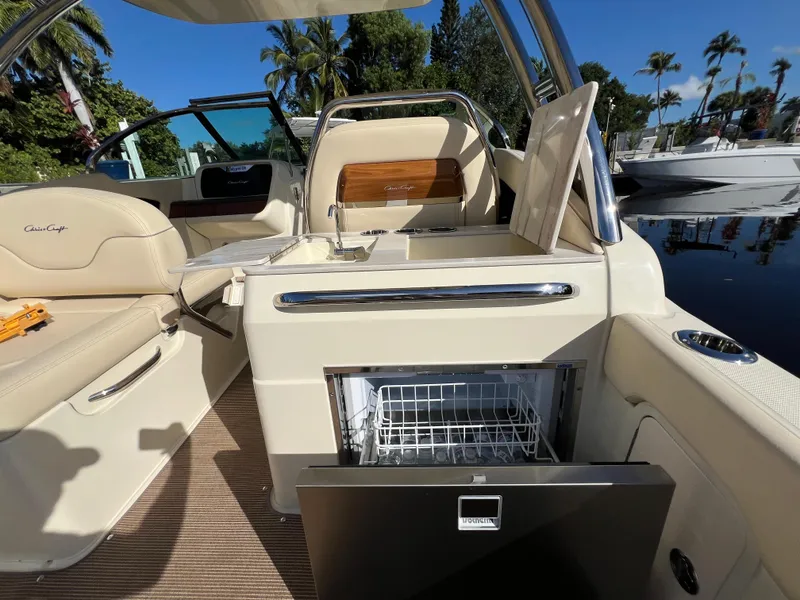 Slide: The Image of 2025 Chris-Craft Calypso 28 interior with open fridge, luxurious seating, and sleek design. - 18