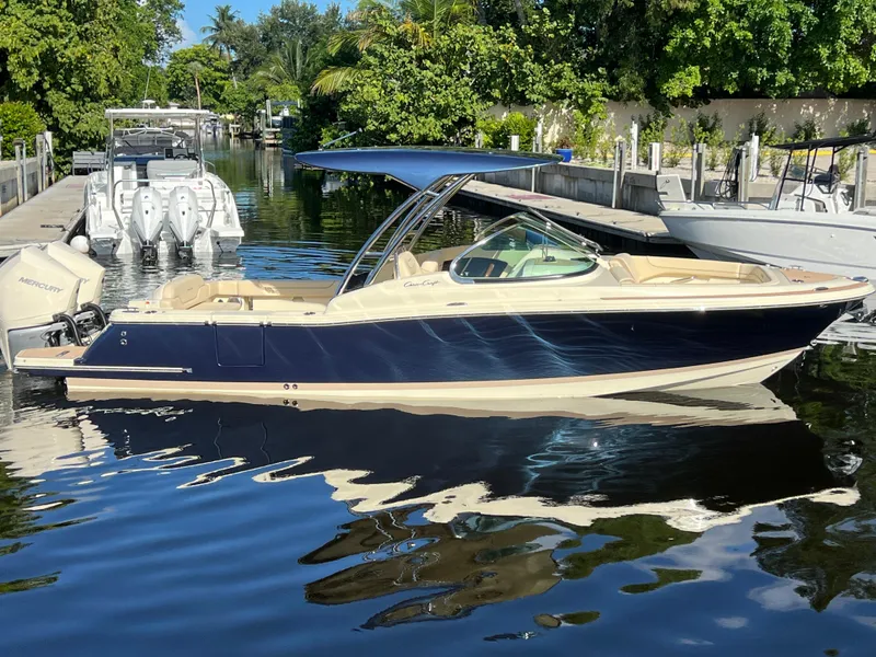 Slide: The Image of 2025 Chris-Craft Calypso 28 boat docked on a sunny day, featuring sleek design and Mercury engines. - 5