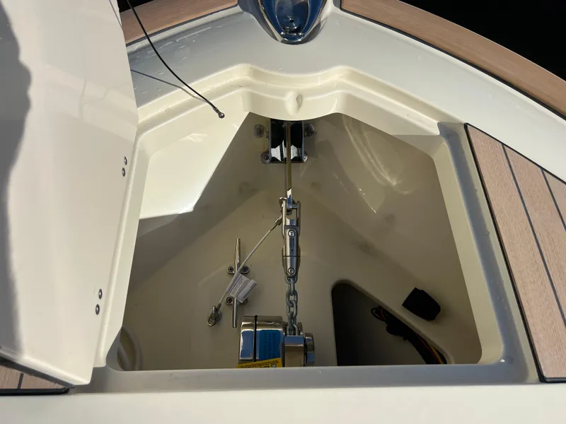 Slide: The Image of Anchor compartment of 2025 Chris-Craft Calypso 28 boat, featuring chain and hardware. - 7
