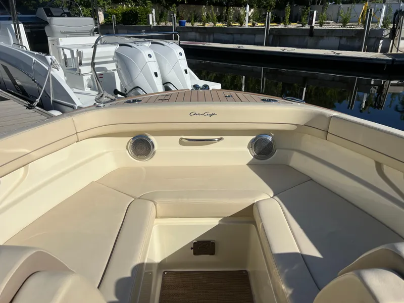Slide: The Image of 2025 Chris-Craft Calypso 28 boat interior with beige seating and docked engines. - 8