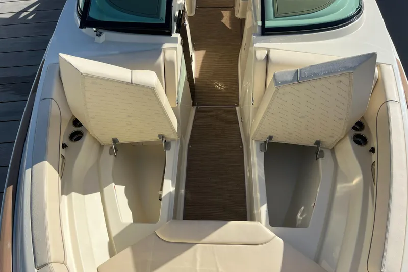 Slide: The Image of 2025 Chris-Craft Calypso 28 boat interior with open storage compartments and cushioned seating. - 9