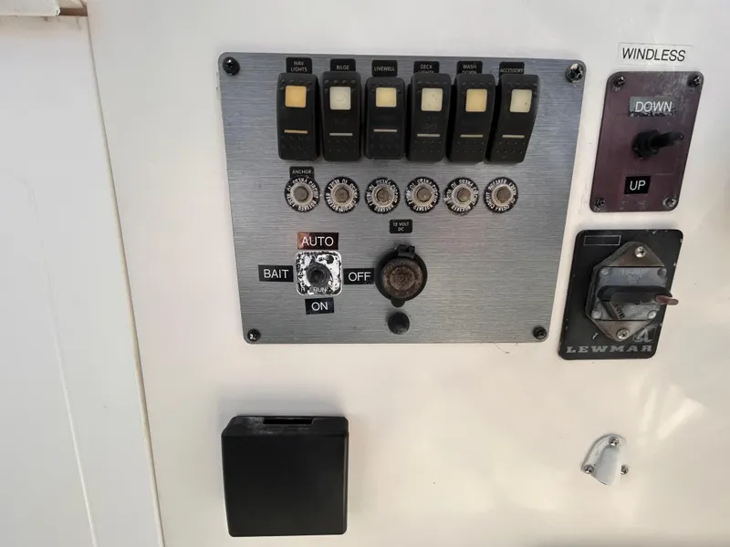Slide: The Image of Control panel of a 2006 Clearwater 2300 WA boat with switches and dials. - 10