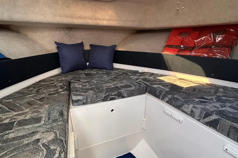 Slide: The Image of 2006 Clearwater 2300 WA cabin interior with patterned cushions and blue pillows. - 17