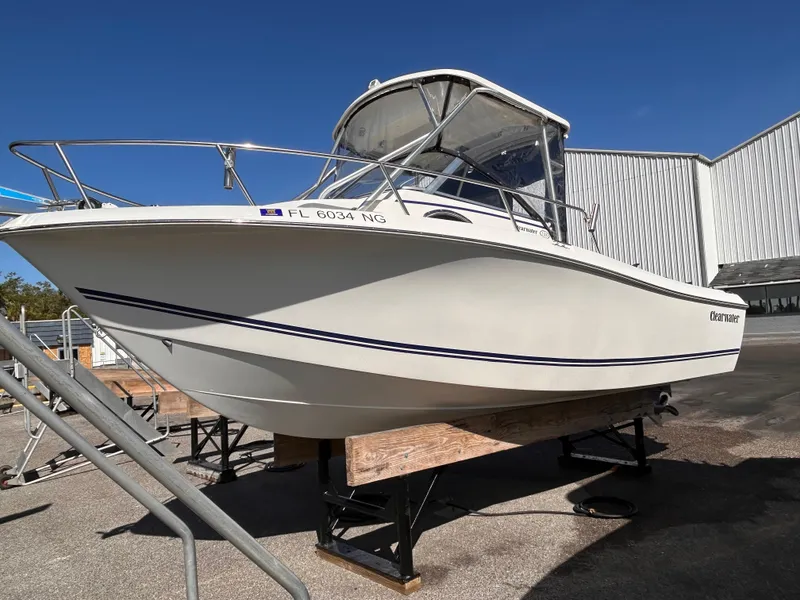 Slide: The Image of 2006 Clearwater 2300 WA boat on display, white hull, sunny day, outdoor setting. - 2