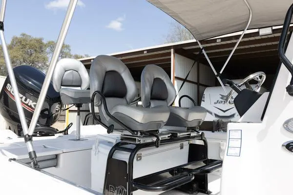 Slide: The Image of 2020 Blue Wave Pure Bay boat interior with dual seats and canopy in storage. - 16