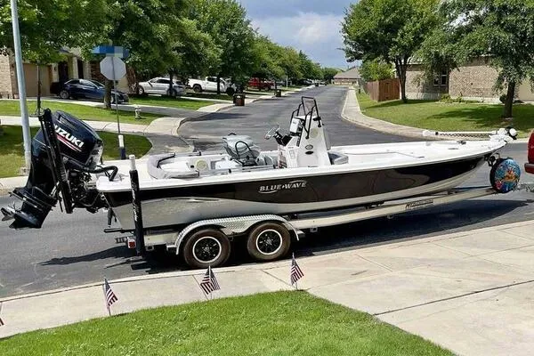 Slide: The Image of 2020 Blue Wave Pure Bay boat on trailer, parked in suburban neighborhood. - 2