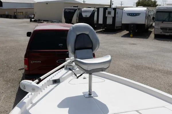 Slide: The Image of 2020 Blue Wave Pure Bay boat with a mounted seat, parked near a red truck and RVs. - 21