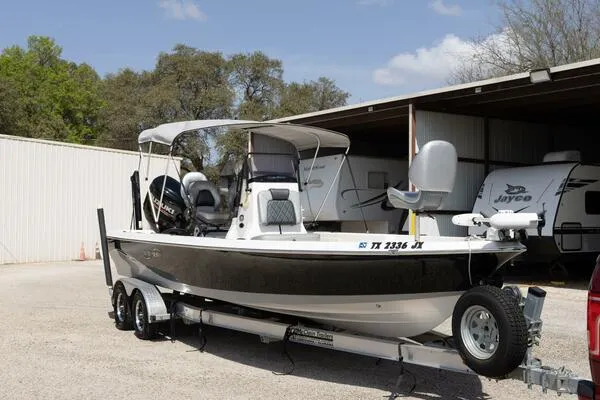 Slide: The Image of 2020 Blue Wave Pure Bay boat on trailer, parked near storage facility. - 46