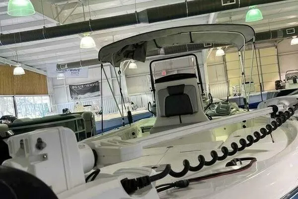 Slide: The Image of 2020 Blue Wave Pure Bay boat displayed in a showroom with overhead lighting. - 7