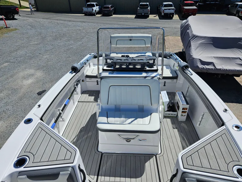 Slide: The Image of 2021 Yamaha Boats 210 FSH Deluxe, spacious deck, modern design, parked outdoors. - 13
