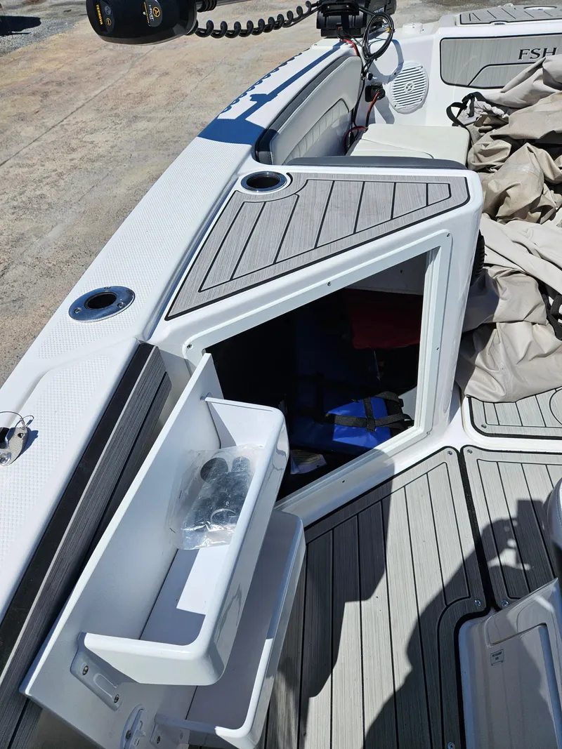 Slide: The Image of 2021 Yamaha Boats 210 FSH Deluxe open storage compartment on deck, showcasing interior space. - 18