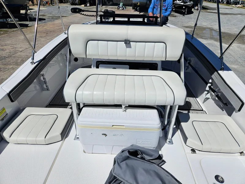 Slide: The Image of 2021 Yamaha Boats 210 FSH Deluxe interior with cushioned seating and storage. - 29