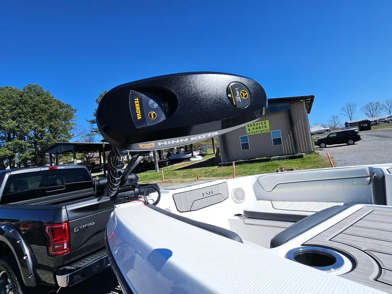 Slide: The Image of 2021 Yamaha Boats 210 FSH Deluxe with Minn Kota trolling motor, parked outdoors. - 3