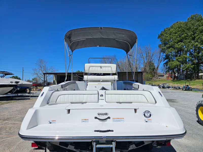 Slide: The Image of 2021 Yamaha Boats 210 FSH Deluxe with canopy, rear view, parked outdoors. - 31
