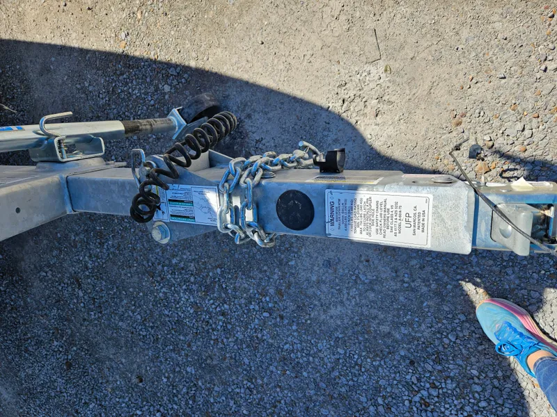 Slide: The Image of Trailer hitch of a 2021 Yamaha Boats 210 FSH Deluxe on gravel surface. - 34