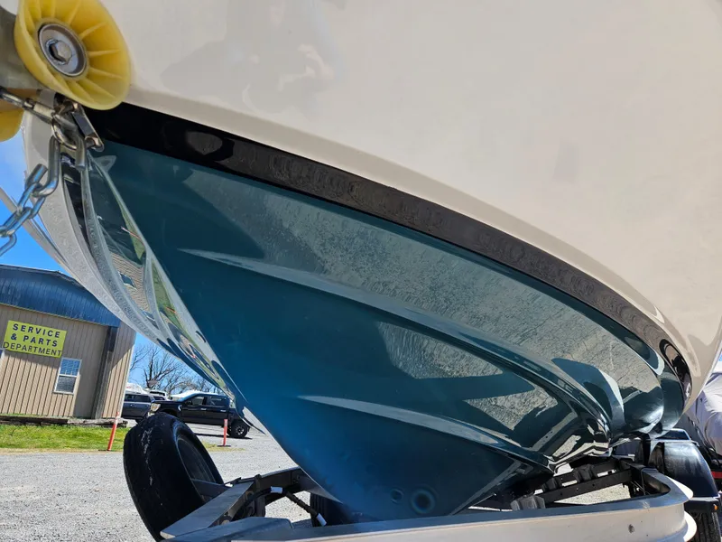 Slide: The Image of 2021 Yamaha Boats 210 FSH Deluxe hull on trailer, showcasing sleek design and vibrant color. - 6