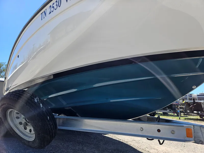 Slide: The Image of 2021 Yamaha Boats 210 FSH Deluxe on trailer, side view, blue hull. - 7