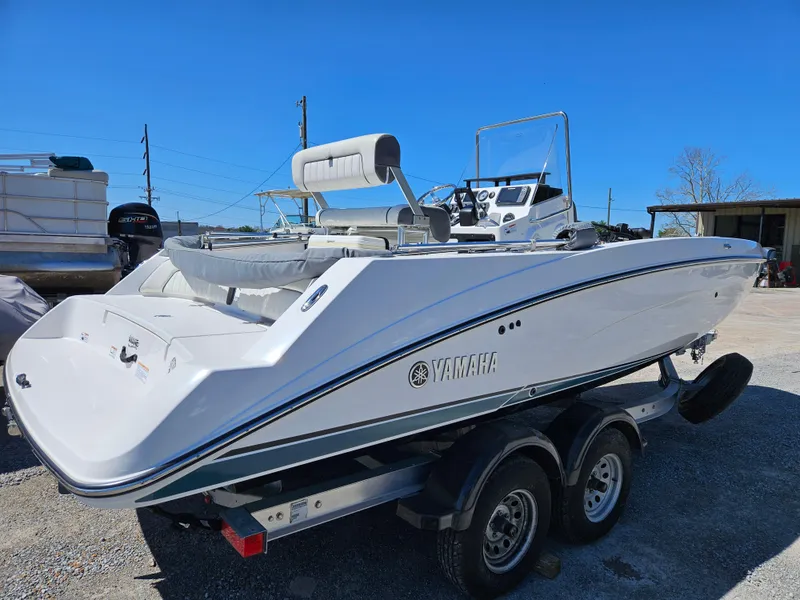 Slide: The Image of 2021 Yamaha Boats 210 FSH Deluxe on trailer, sleek design, outdoor setting. - 8