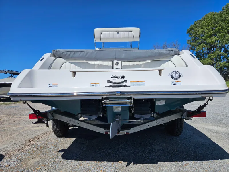 Slide: The Image of 2021 Yamaha Boats 210 FSH Deluxe, rear view, parked on trailer, clear blue sky. - 9