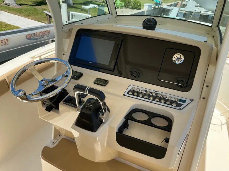 Slide: The Image of 2019 Scout 275 LXF boat dashboard with steering wheel and control panel. - 12