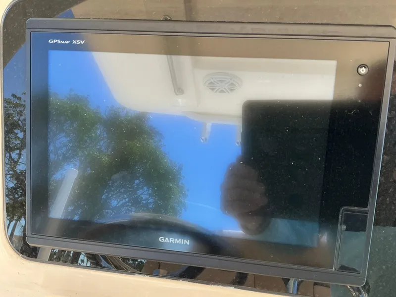 Slide: The Image of Garmin GPSmap XSV on 2019 Scout 275 LXF boat dashboard, reflecting sky and trees. - 13