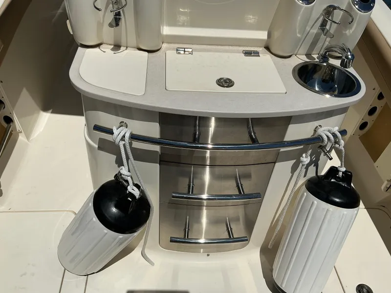 Slide: The Image of 2019 Scout 275 LXF boat interior with sink, storage, and fenders. - 16