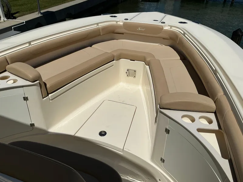 Slide: The Image of 2019 Scout 275 LXF boat interior with beige seating and storage compartments. - 20