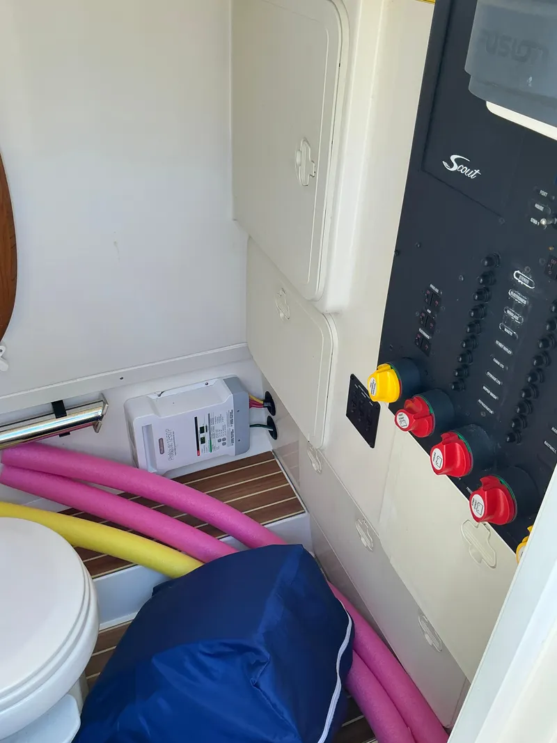 Slide: The Image of 2019 Scout 275 LXF boat interior with control panel, storage, and colorful pool noodles. - 24