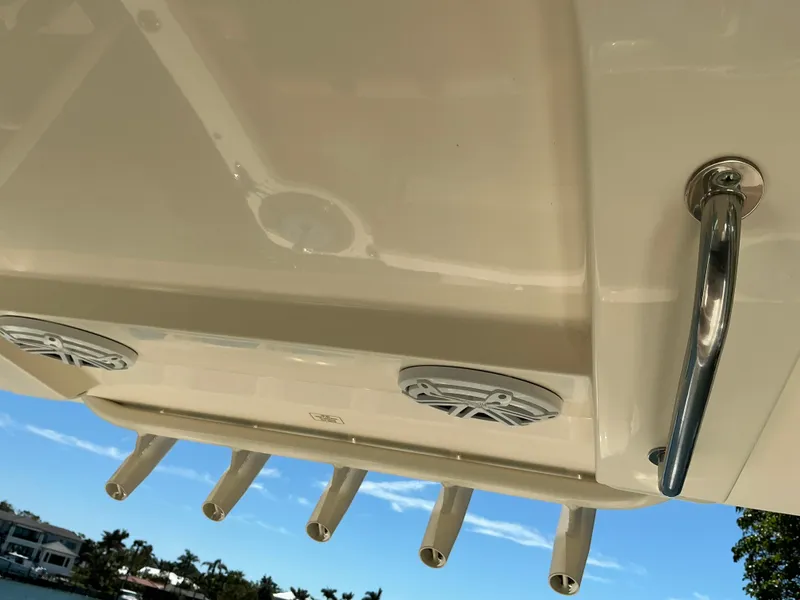 Slide: The Image of 2019 Scout 275 LXF boat with rod holders and speakers, under a clear blue sky. - 28