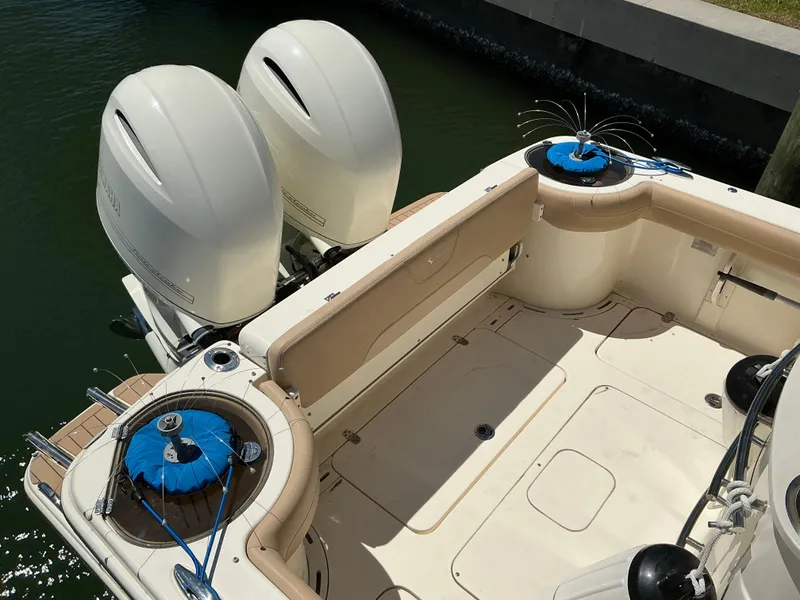 Slide: The Image of 2019 Scout 275 LXF boat with dual outboard engines, docked in calm water. - 7