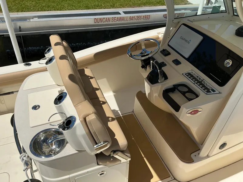 Slide: The Image of 2019 Scout 275 LXF boat interior with helm, seating, and control panel. - 8