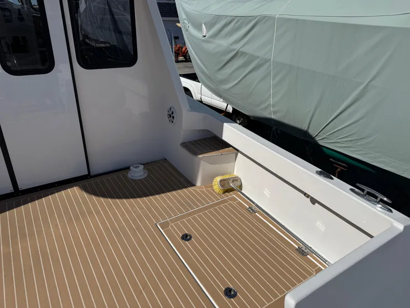 Slide: The Image of Cape Powercat 3500 PH 2020 model boat deck with wood finish and storage hatch. - 15