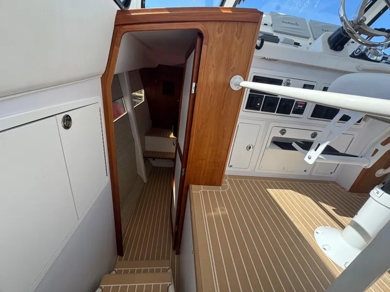 Slide: The Image of Interior view of 2020 Cape Powercat 3500 PH boat with wooden accents and control panel. - 24