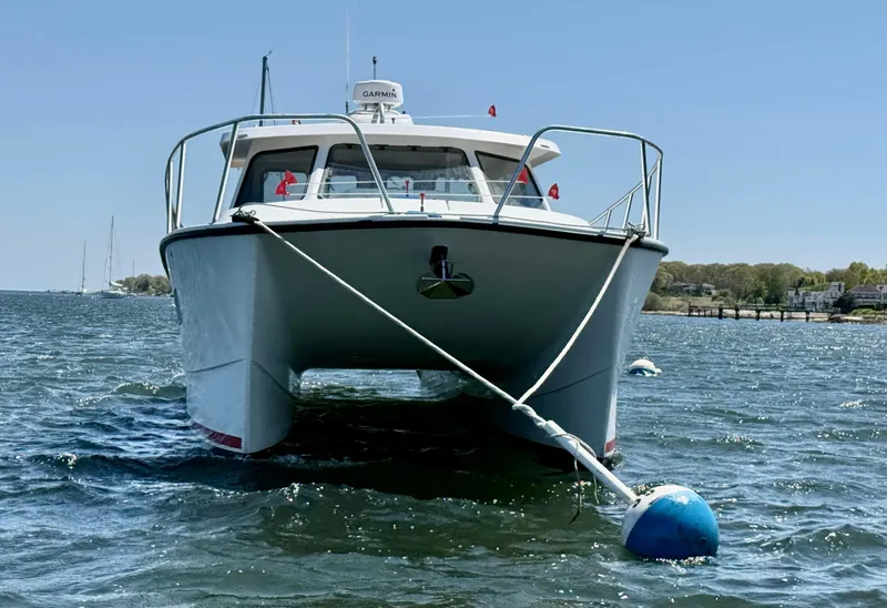 Slide: The Image of 2020 Cape Powercat 3500 PH boat anchored on water, front view. - 6
