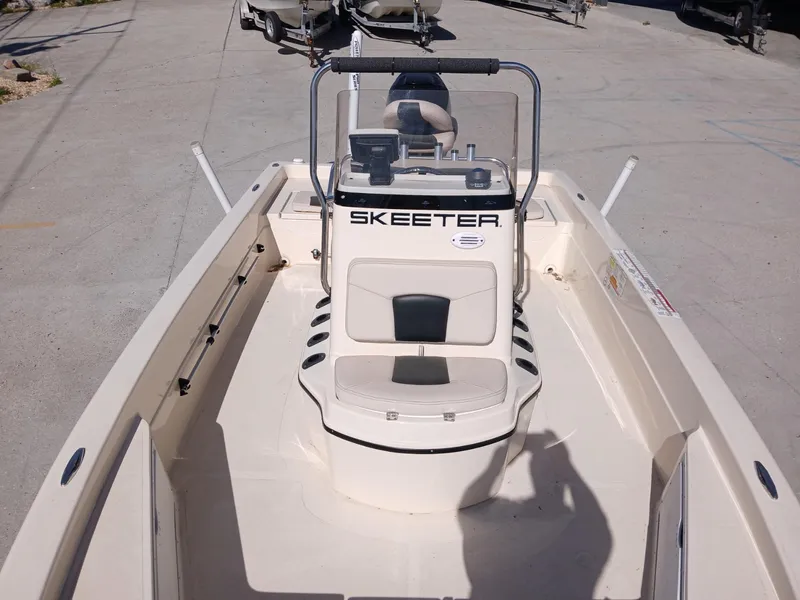 Slide: The Image of 2010 Skeeter 20 ZX boat interior with console and seating, parked on concrete. - 2