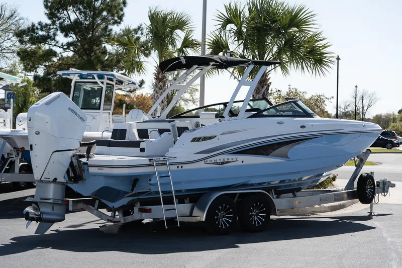 The Image of 2025 Monterey M-65 boat on trailer, parked near palm trees. - 0