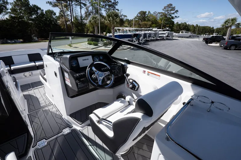 Slide: The Image of 2025 Monterey M-65 boat cockpit with modern steering and seating, parked outdoors. - 17