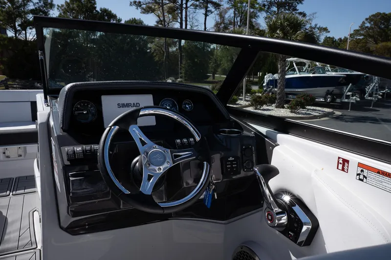 Slide: The Image of 2025 Monterey M-65 boat dashboard with steering wheel and controls, featuring modern design elements. - 18