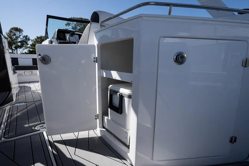 Slide: The Image of 2025 Monterey M-65 boat interior with open storage compartment and cooler. - 23