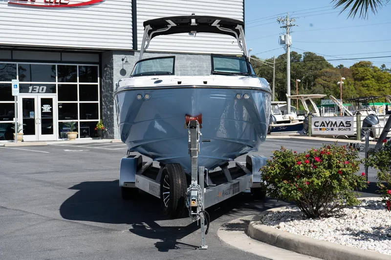 Slide: The Image of 2025 Monterey M-65 boat on trailer outside dealership, surrounded by plants and signage. - 4