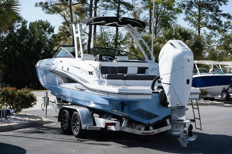 Slide: The Image of 2025 Monterey M-65 boat on trailer, parked outdoors, featuring sleek design and powerful outboard motor. - 5