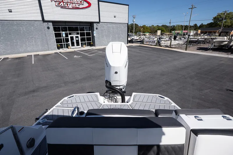 Slide: The Image of 2025 Monterey M-65 boat at dealership, rear view with outboard motor, sunny day. - 9