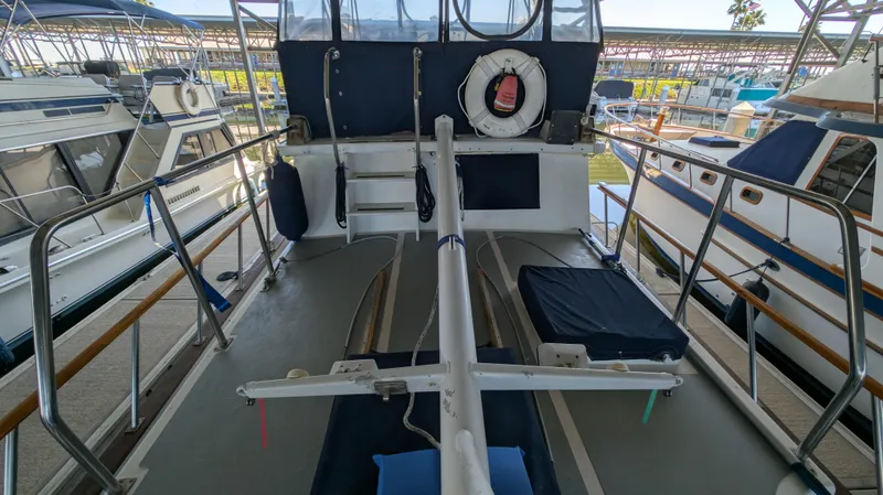 Slide: The Image of 1982 Monk 36 boat deck with railing, life preserver, and docked boats in marina. - 14