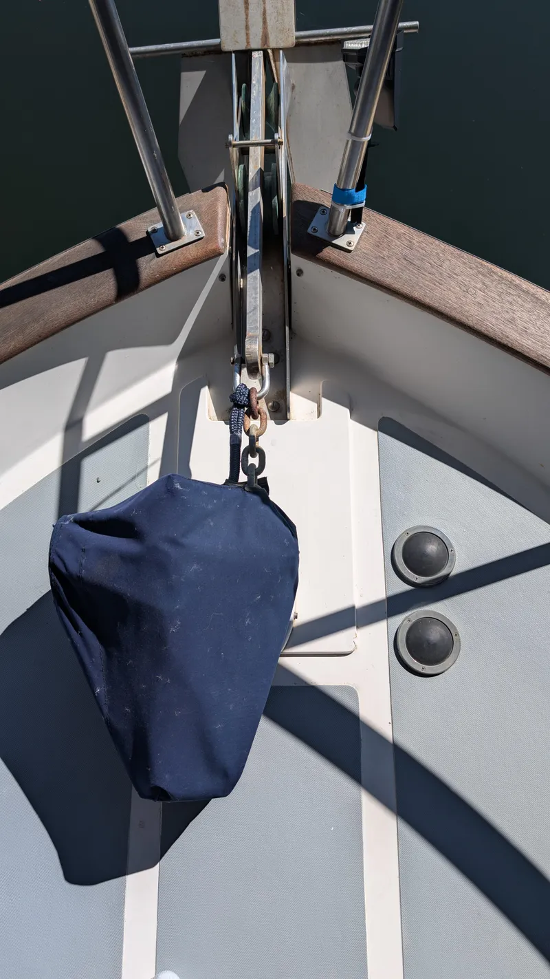 Slide: The Image of Bow of a 1982 Monk 36 boat with anchor and blue cover. - 18