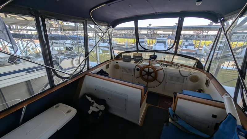 Slide: The Image of Interior view of a 1982 Monk 36 boat cockpit with steering wheel and navigation equipment. - 26
