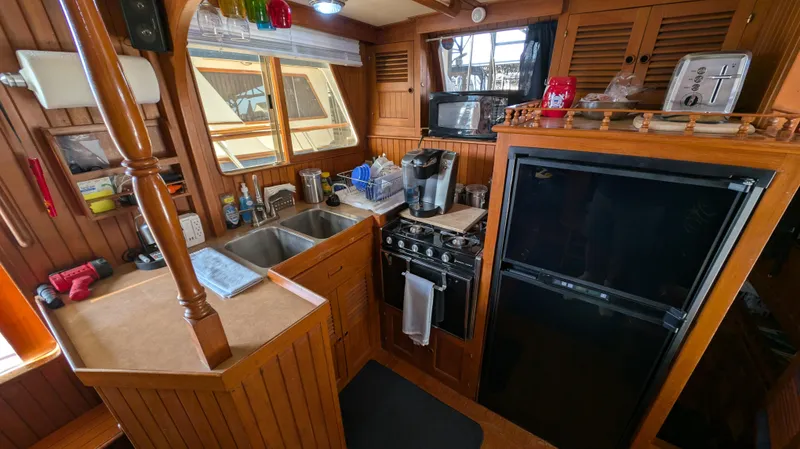 Slide: The Image of Cozy 1982 Monk 36 boat kitchen with wooden cabinetry and modern appliances. - 30